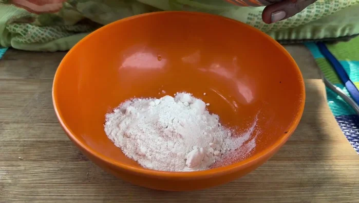 In a bowl, mix flour, cornflour, pepper powder, cloves, schezwan sauce, and salt.