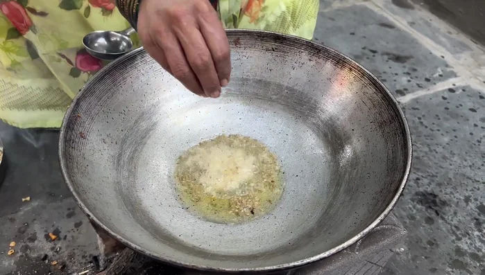 Heat oil in a pan, add cumin seeds, ginger, garlic, and green chilies. Fry until fragrant.