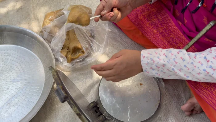 Roll out the papads using a spoon to form round shapes on a plastic sheet. Then press another plastic sheet over the top to make uniform thickness.