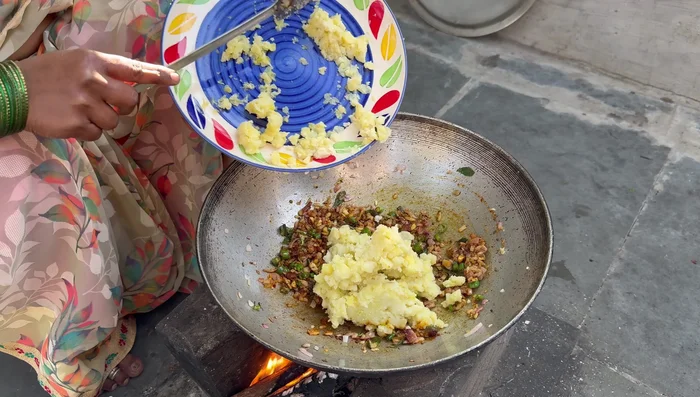 Add mashed potatoes to the spice mixture. Season with salt and coriander.