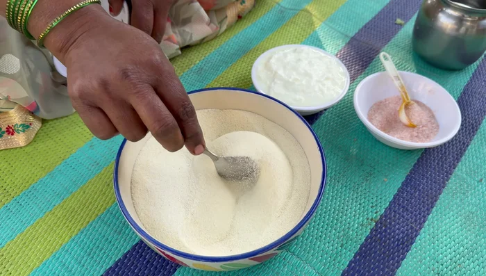 Prepare semolina batter: Mix semolina, curd, and water. Let it rest for 10-15 minutes.