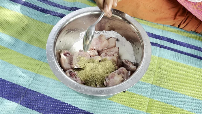 Add the spices (coriander powder, red chili powder, garam masala, cumin, turmeric powder, and salt) to the chicken and curd mixture. Mix well.
