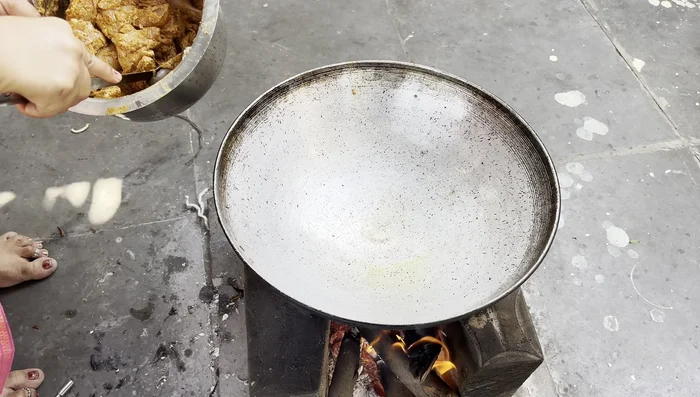 Cook the chicken mixture on the stove until the water evaporates, allowing the chicken to cook and the curd to thicken. Place a plate on top to help with the evaporation process.