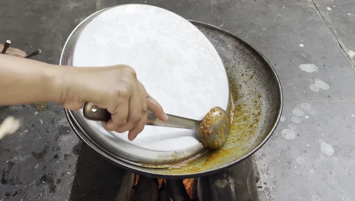 After the chicken has cooked and the water from the curd has evaporated, add hot water.