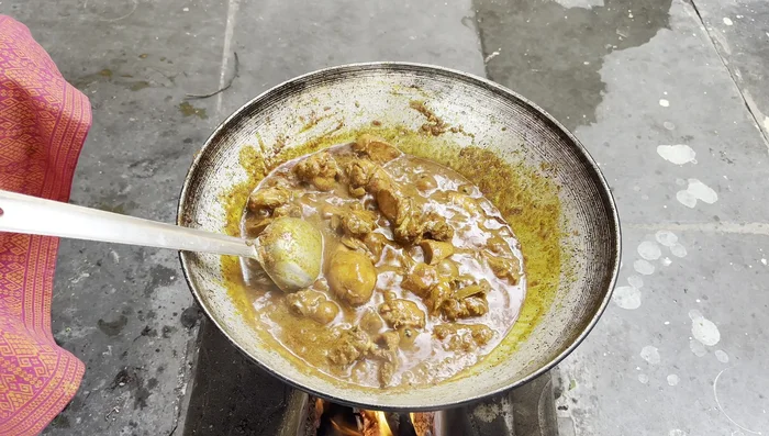 After the chicken is cooked, add the previously ground crushed spices and garnish with coriander.