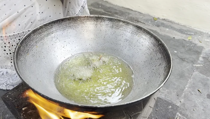 Carefully drop spoonfuls of batter into the hot oil and fry until golden brown and crispy.