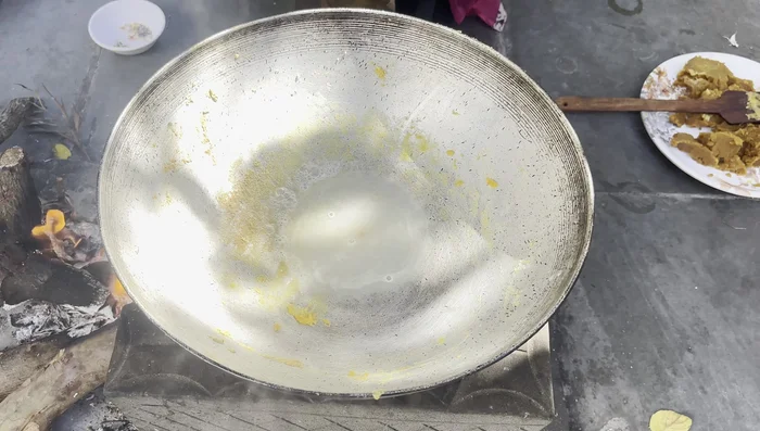 Prepare the sugar syrup (taari): In the same pan, add half a cup of water and one cup of sugar. Stir continuously until a thick syrup forms.