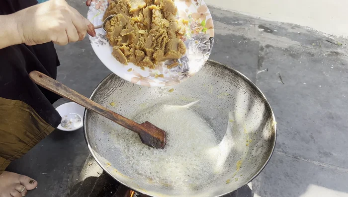 Combine the fried flour mixture with the sugar syrup. Stir well to ensure everything is thoroughly mixed. Continue cooking until the mixture thickens.