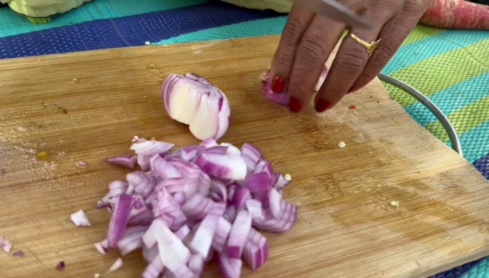 While the pasta steams, finely chop the onions, carrots, tomatoes, and capsicum (bell peppers).