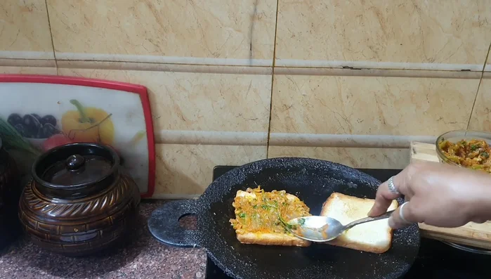 Spread the cooked vegetable mixture on one slice of bread.
