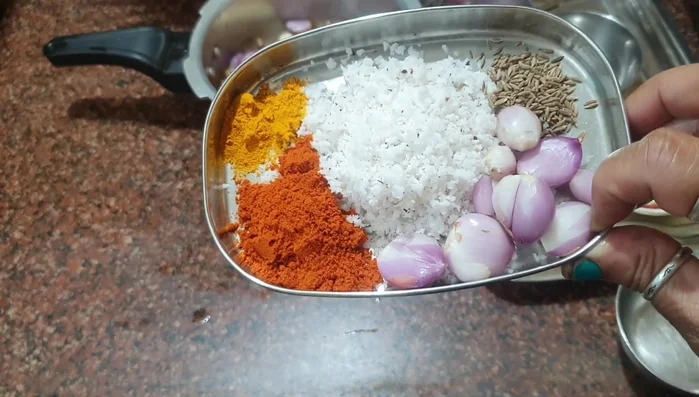 Grind together a little coconut, cumin, onion, turmeric powder, and coriander powder into a paste.