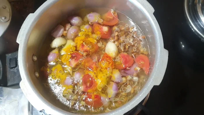 Before boiling, add a little turmeric powder to the lentils in the cooker and cook for four whistles.