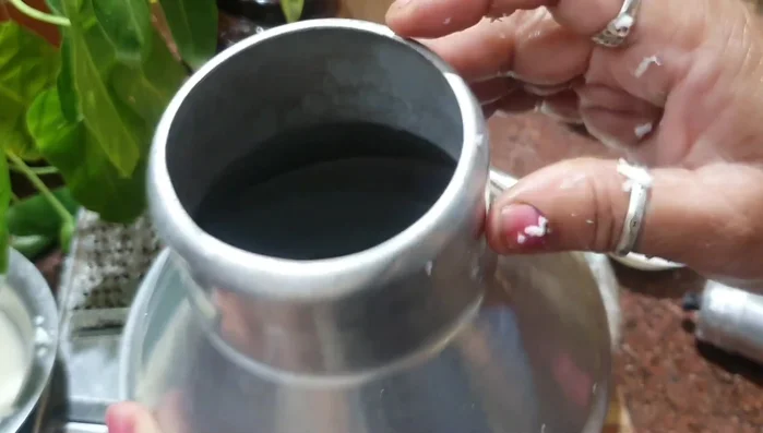 Fill the pudding pot with the tapioca mixture. Add coconut in the center. Add 1 liter of water to the pot.