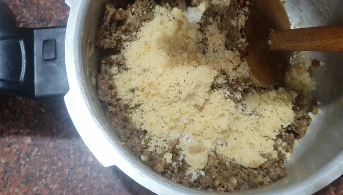 Add grated coconut, jaggery, and cardamom powder to the mashed sirupairu. Mix well.
