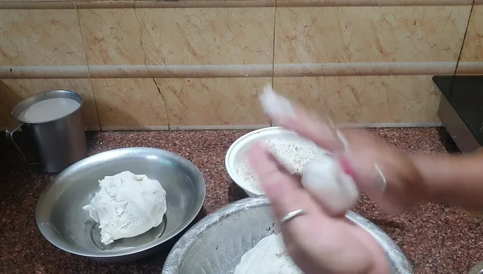 For the pure kozhukatta, take small portions of the dough and shape them into small balls with a small indentation in the center. Fill with the prepared coconut mixture, close, and gently shape into a dumpling.