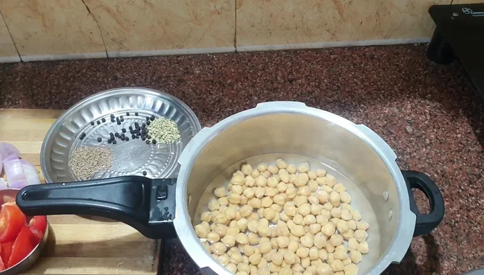 Cook soaked chickpeas in a cooker with enough water and 50% of the required salt for four whistles (28.72).
