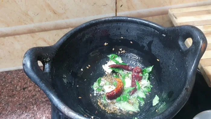 Add curry leaves and fry the small onions until glassy.