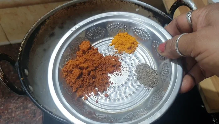 Add turmeric powder, pepper powder, chicken masala, and salt to the onion mixture. Stir well.