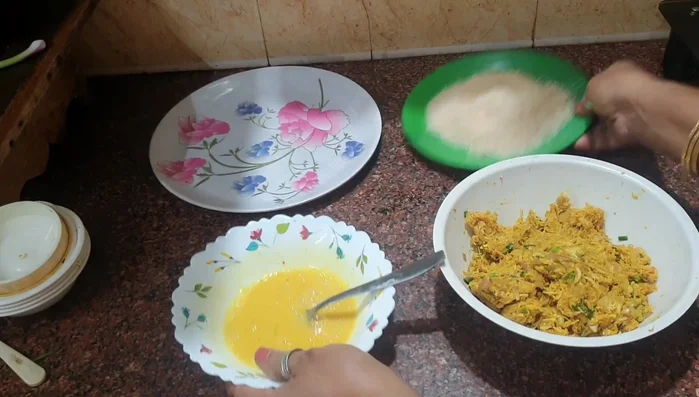 Beat an egg with a little salt and pepper. Add the chicken mixture to the beaten egg, then coat with breadcrumbs.