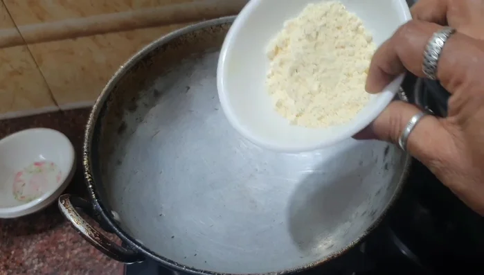 Heat groundnut flour in a pan until the raw smell is gone.