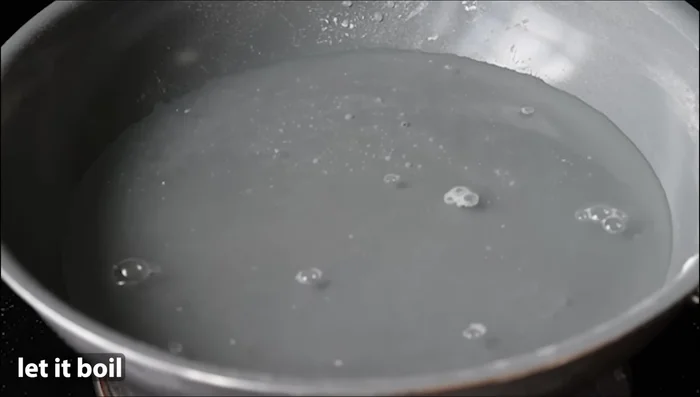 Add 1 ½ cups water, ½ teaspoon salt, and 1 teaspoon ghee to the pan. Bring to a boil. (225.28)