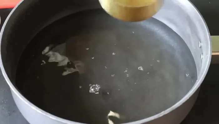 Prepare Kozhukatta Payasam: Boil 3 cups of water, add 2 tablespoons soaked dal flour, and cook until tender. (974.199)