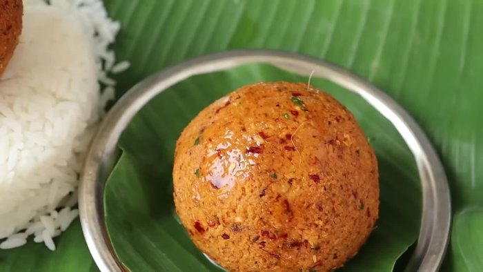 Grind coconut, green chilies, ginger, and curry leaves using a mortar and pestle until a smooth paste is formed.