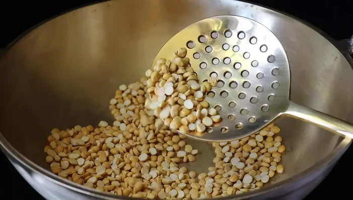 Next, add the ground dal powder to the pan.