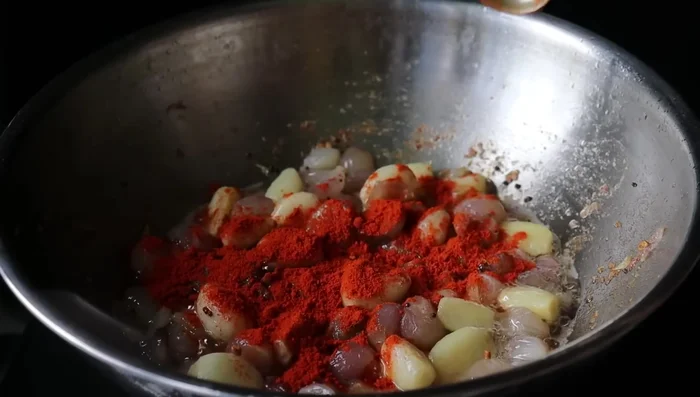 Add turmeric powder, chili powder, and coriander powder. Fry until fragrant.