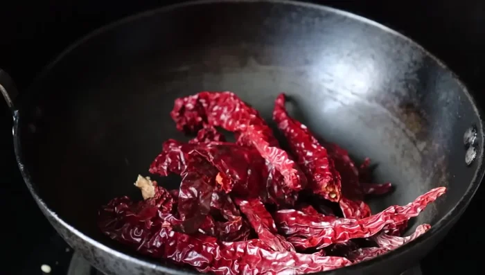 In the same pan, fry 20 red chilies until crispy.