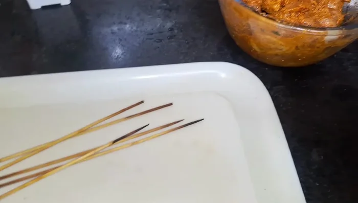 Thread the marinated chicken onto skewers, leaving a small gap between each piece.