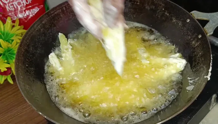 Fry the potatoes in hot oil until golden brown and crispy, turning frequently.