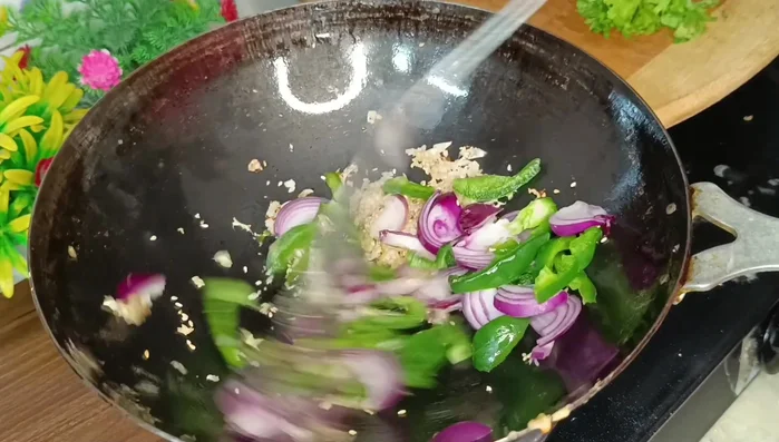 Add onion and capsicum, stir-frying for about 30 seconds.