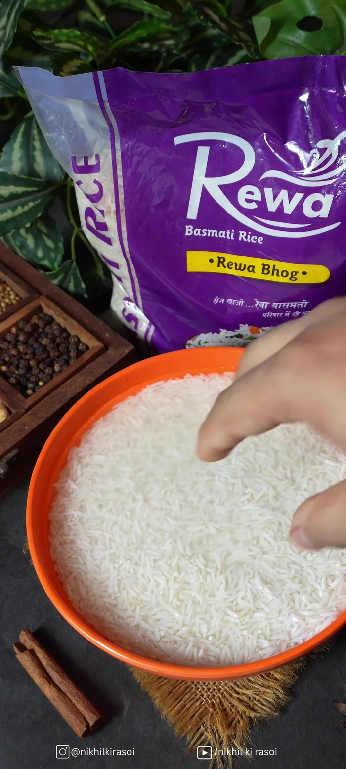 Soak Basmati rice in water with whole spices, lemon, chili, and salt.