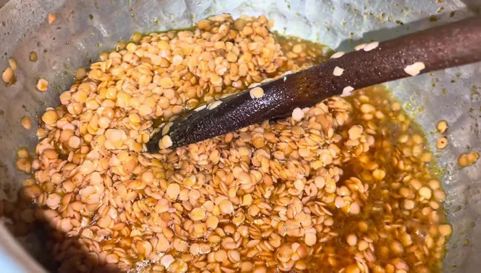 Once the lentils are cooked and the water has dried up, add more water as needed. Stir well and let it simmer.
