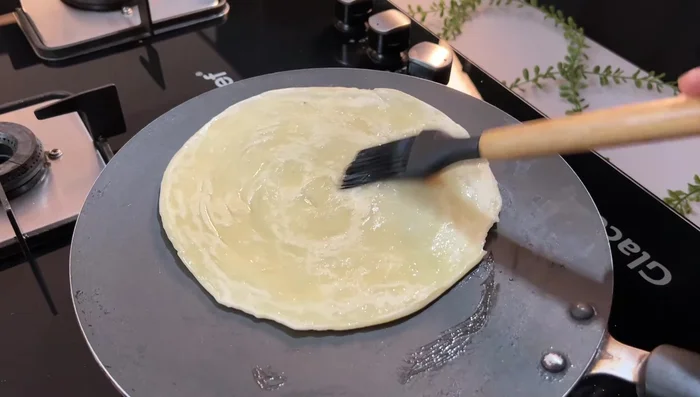 Cook the paratha on a hot iron pan, applying a little oil to both sides until well browned.