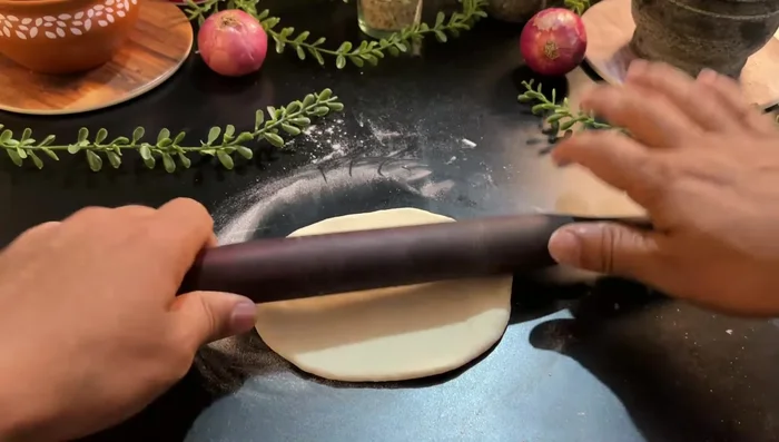 Sprinkle dry flour on the peda, press, and roll like a roti. Cook on an iron pan (not non-stick) until browned on both sides.