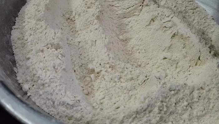 Divide the flour mixture into two parts. Add the ginger-curry leaf paste to one part.