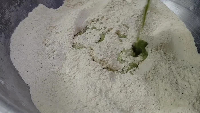 Gradually add water to the flour mixture, mixing until a smooth dough forms.