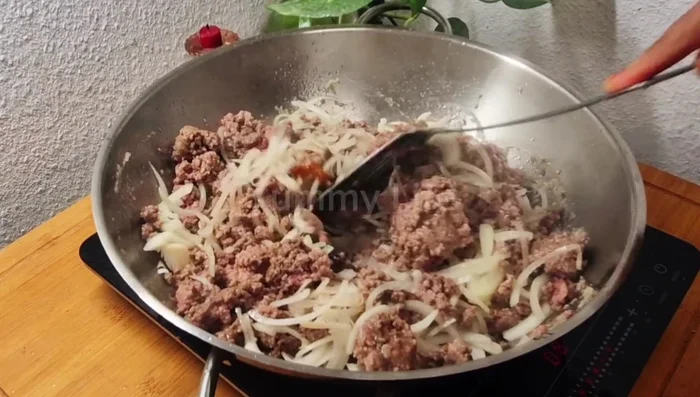 Add 2 chopped onions and mix well. Add spices (surkh mirch, salt, turmeric, coriander powder, garam masala) to taste and fry.