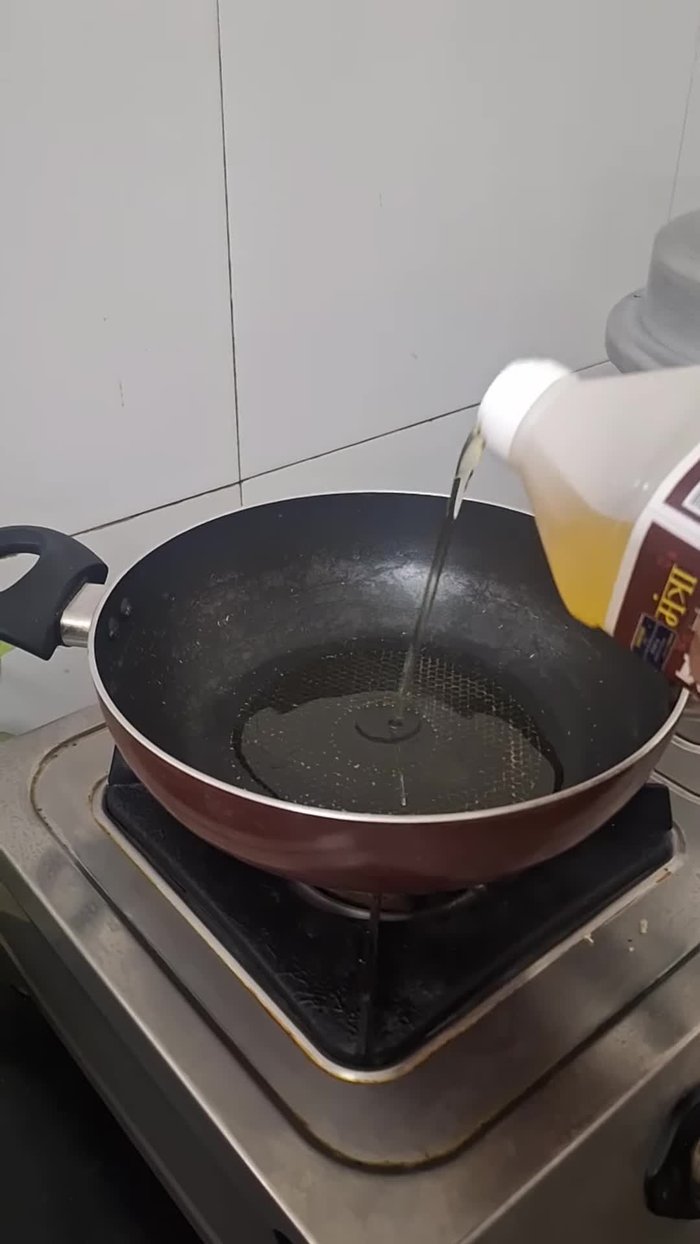 In a pan, heat sesame oil. Add mustard seeds, coriander seeds, red chilies, cumin, and chopped small onion. Mix well.