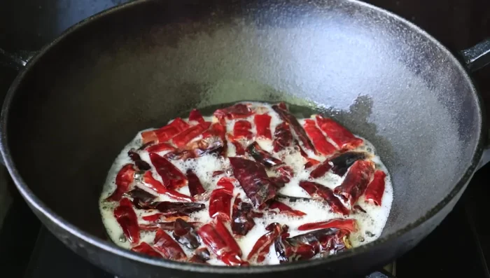 Lightly fry the chilies. Then, add curry leaves and fry well.