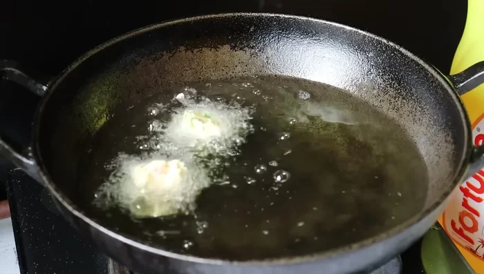 Add spoonfuls of batter to hot oil, shaping them into vadas. Fry until golden brown on both sides, turning occasionally. Maintain medium heat to prevent burning or sogginess.