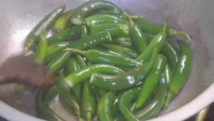 Lightly fry the green chilies in oil. Set aside. (214.64)