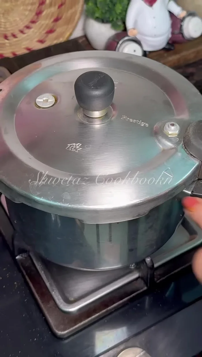Close the cooker lid and let it boil for two whistles.