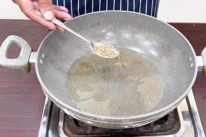 Heat cooking oil in a pan. Add cumin seeds and crackle them for half a minute.
