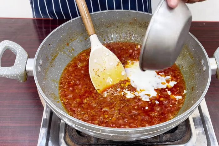 Add curd, coriander powder, cumin powder, and garam masala powder. Cook until the rawness of the curd is gone.
