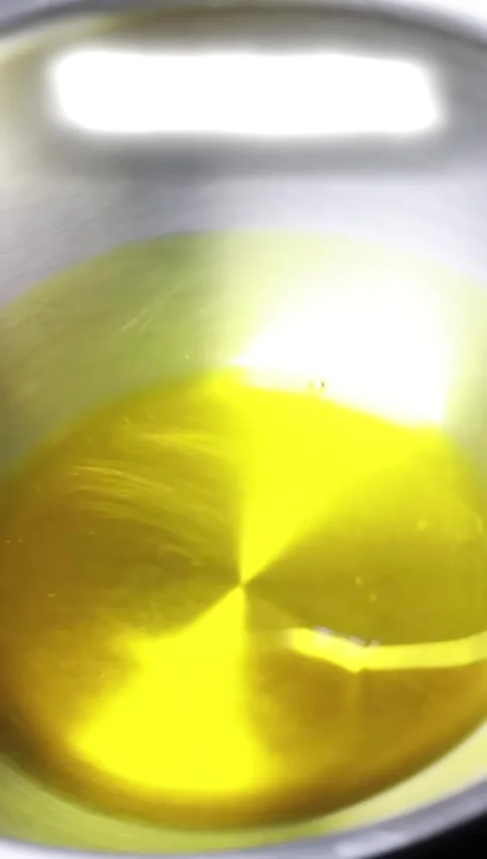 Heat mustard oil (or desi ghee) in a kadhai/pan. Add garlic and fry until golden brown. Add green chilies and fry briefly.
