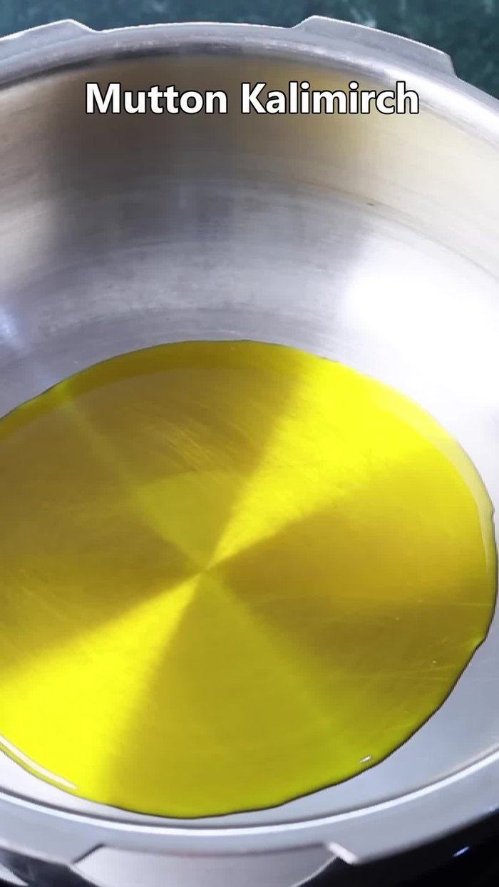 Heat mustard oil in a pressure cooker. Add bay leaf, cardamoms, cloves, black peppercorns, and cinnamon. Fry for a few moments to release their aroma.