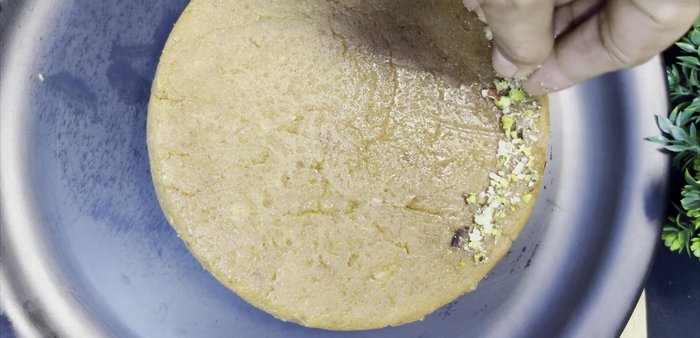 Once cooled, remove the sweet from the tin. Decorate with chopped pistachios and almonds. Cut into desired shapes and serve.
